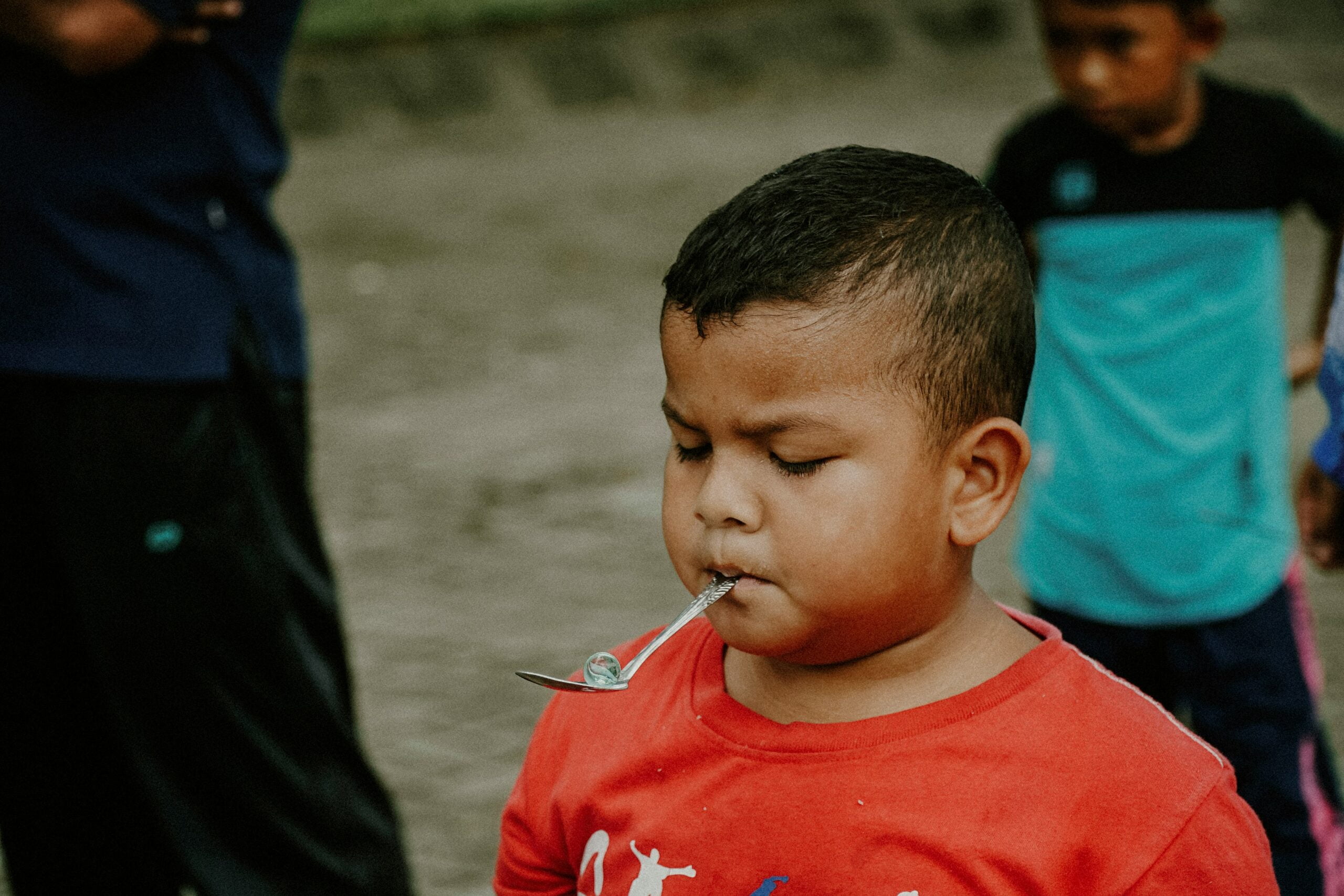 passing down clothes, a young boy with a spoon in his mouth