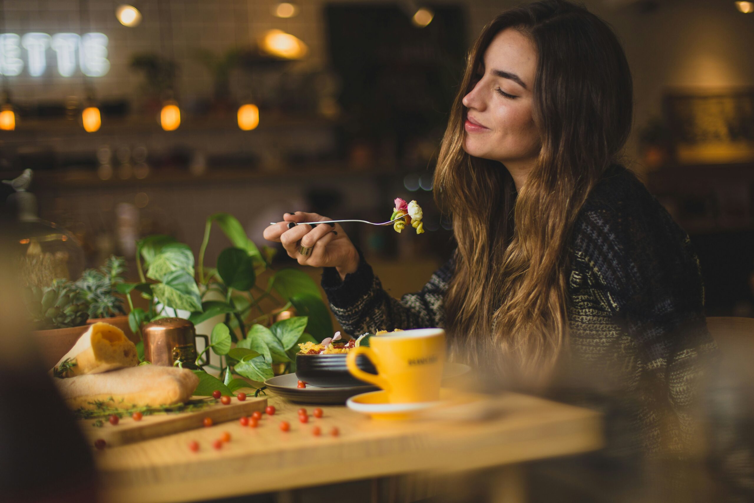 emotional eating, woman holding fork in front table